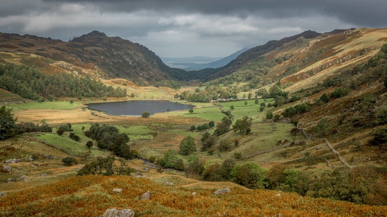 View over Watendlath Tarn in autumn, surrounded by mountains, Borrowdale, the Lake District